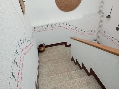 Staircase wall decorated with black and red prehistoric-inspired border stencils