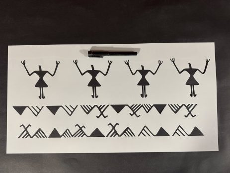 Printed layout of a prehistoric stencil design with marker for scale